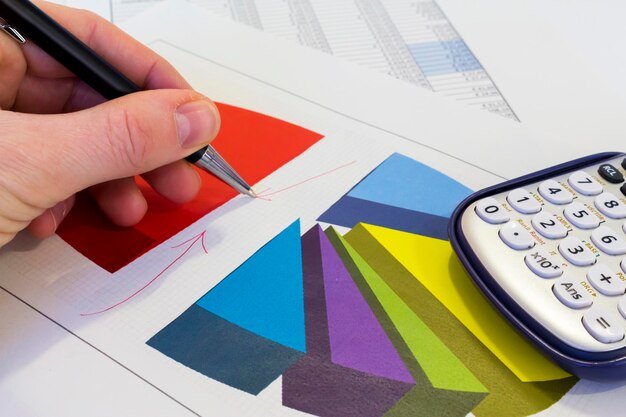 Cropped image of business person analyzing data on paper in office