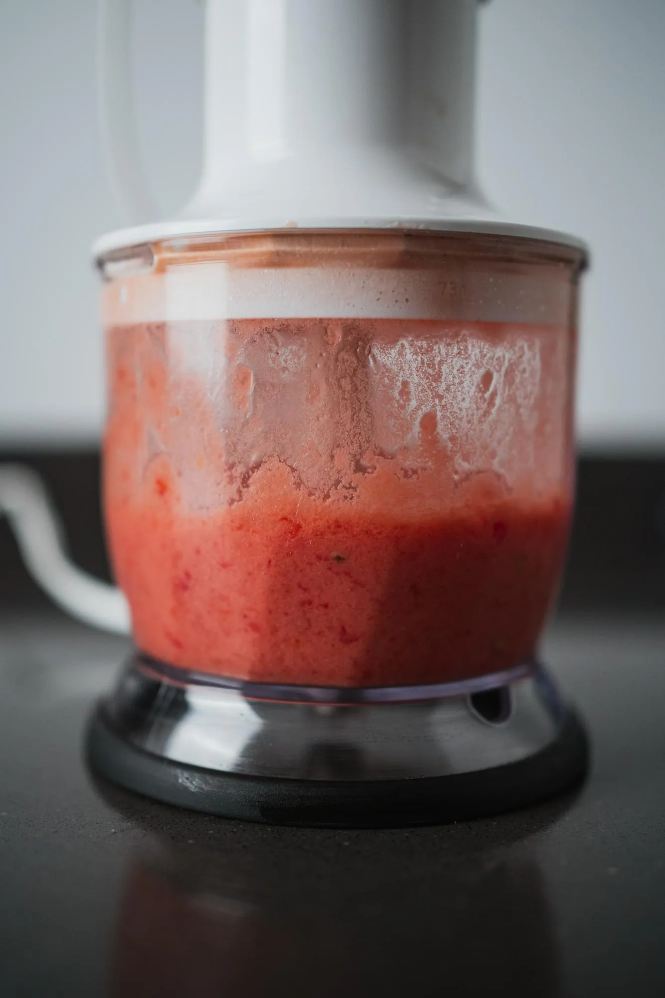 Crushing tomato in a blender with olive oil salt oregano and garlic for spanish breakfast
