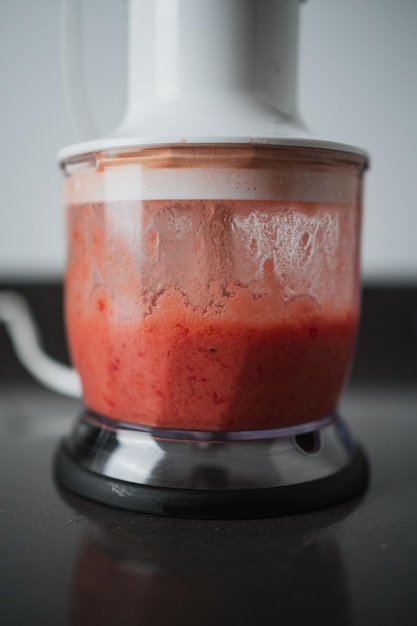 Crushing tomato in a blender with olive oil salt oregano and garlic for spanish breakfast