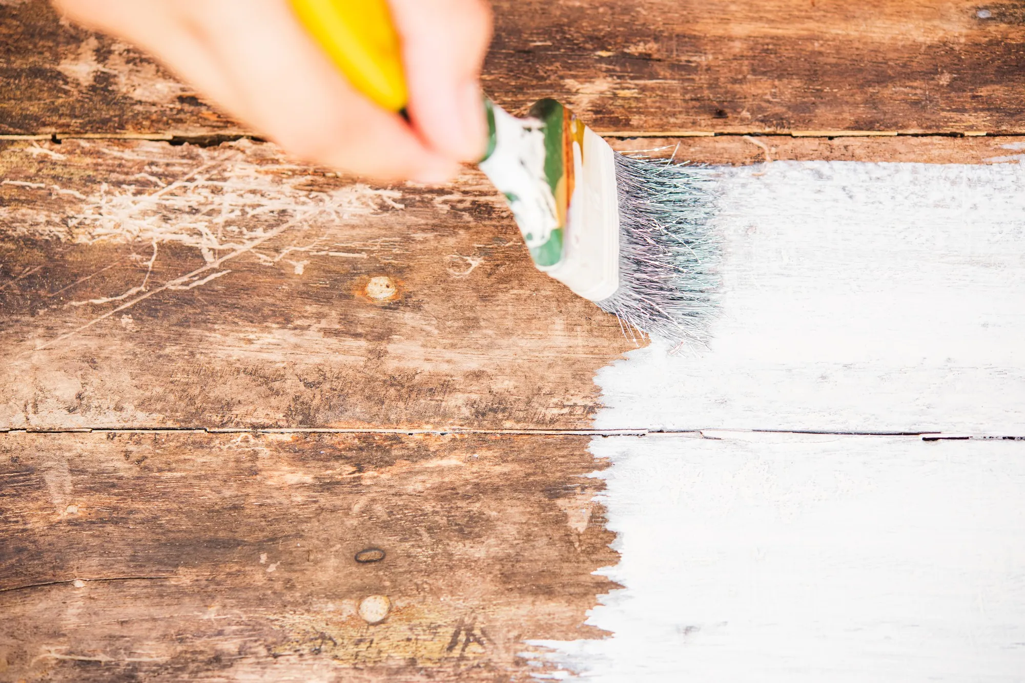 diy woman hand using paintbrush decorating or painting old wood brown color to white color