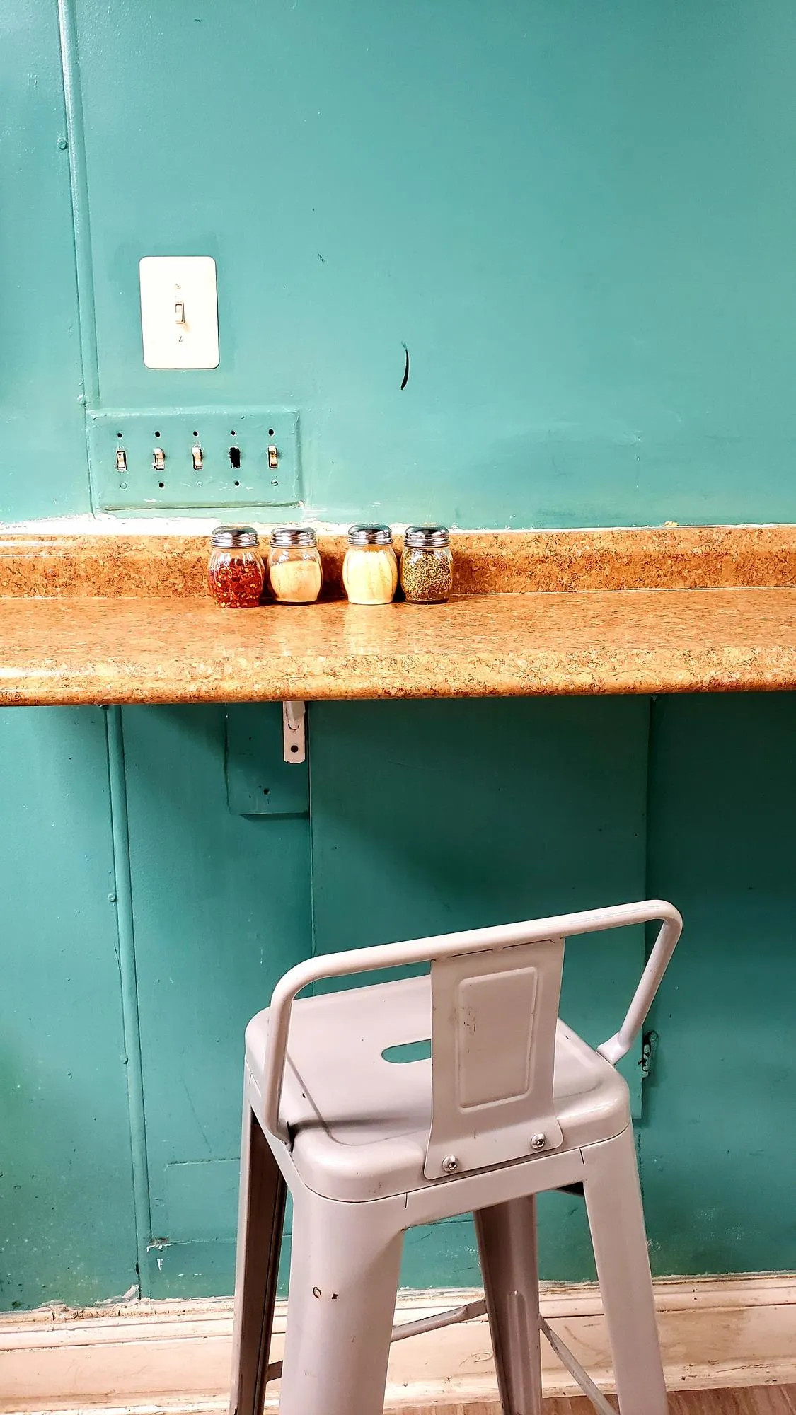 Empty chairs and table against wall