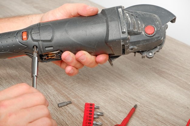 An engineer repairing an angle grinder Assembling the tool in the process of repair