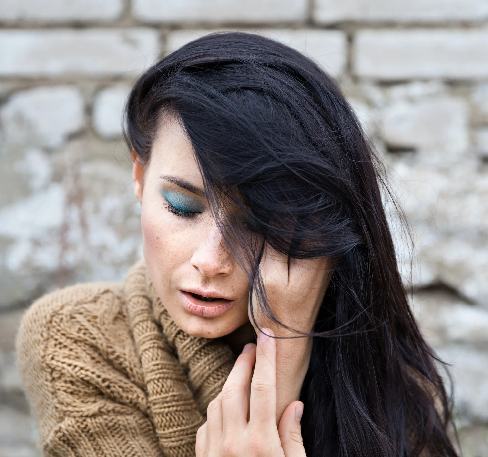 Girl against old brick wall
