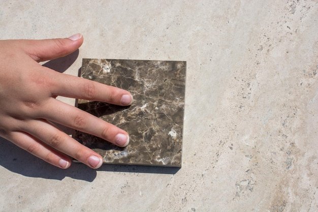 Hand on piece of marble stone