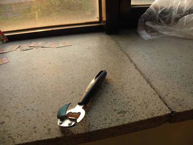 High angle view of can opener on window sill