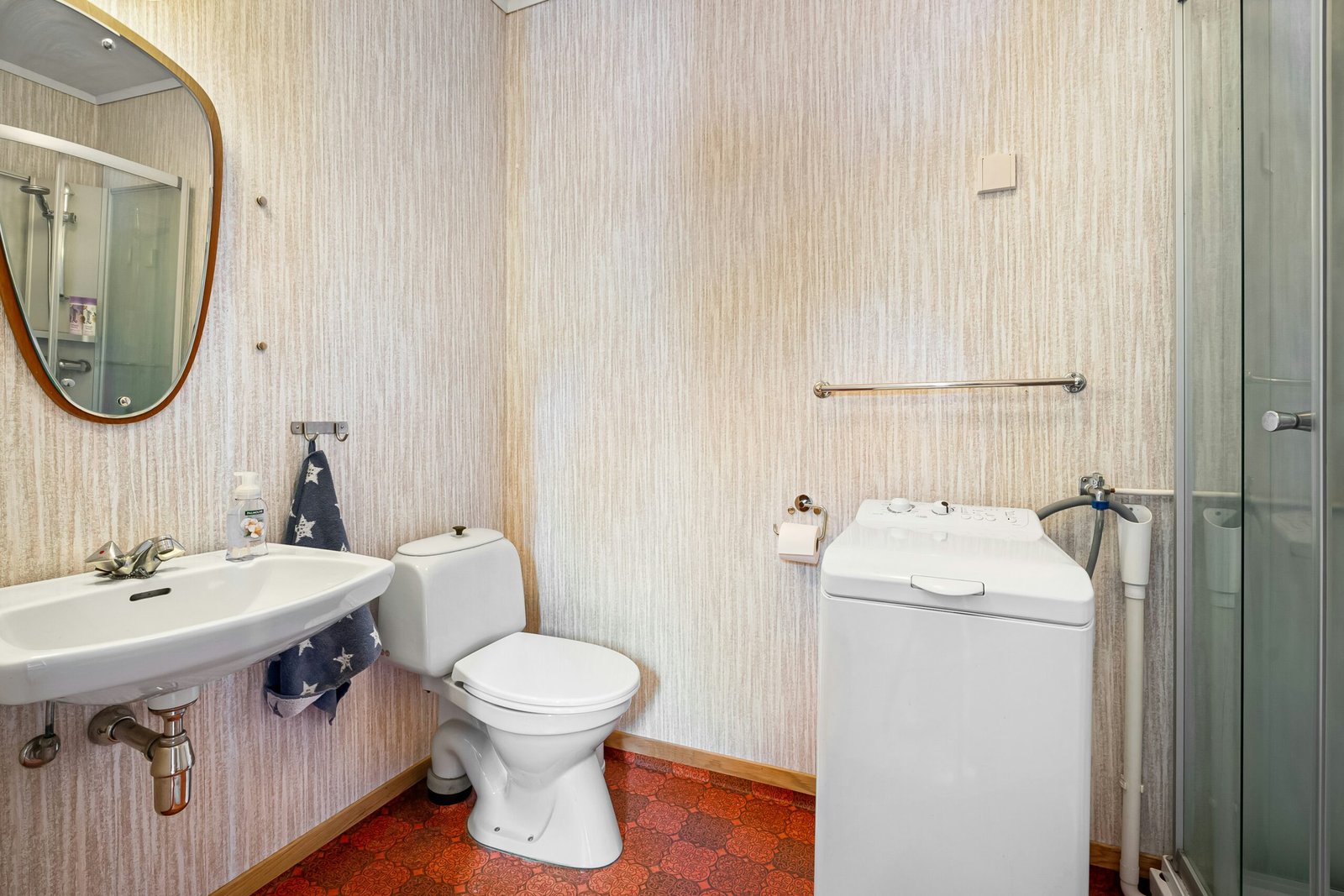 A bathroom with a toilet, sink, and shower