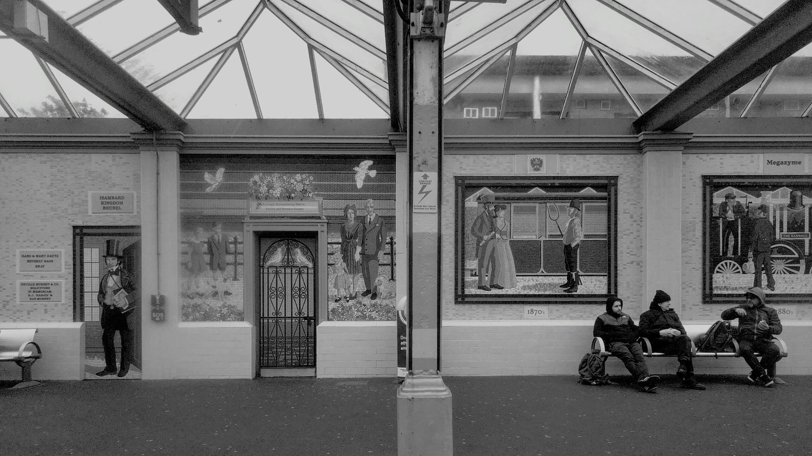 People waiting inside a building with murals