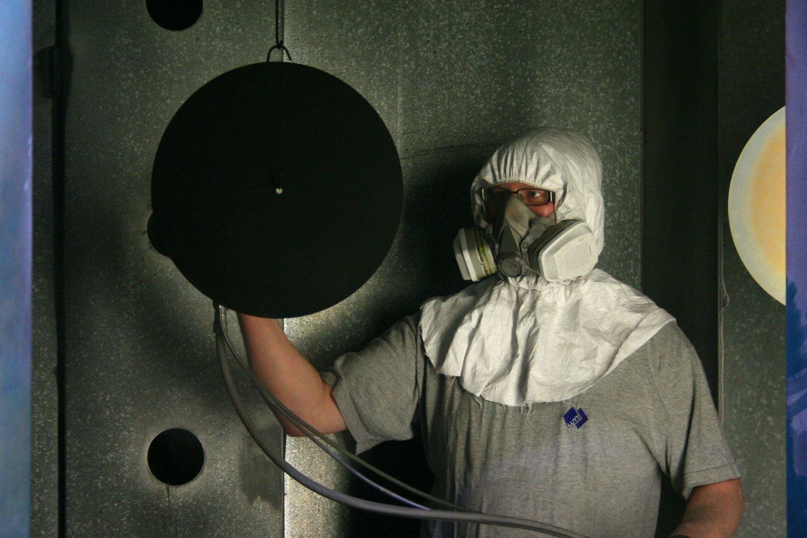 Person in hazmat suit holding a circular object