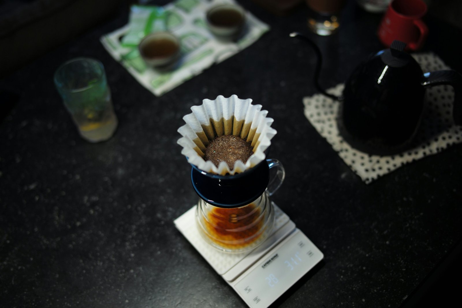 a cup of coffee with whipped cream and a spoon on a table