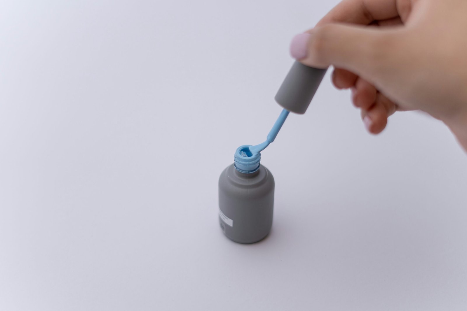 a hand holding a white tube