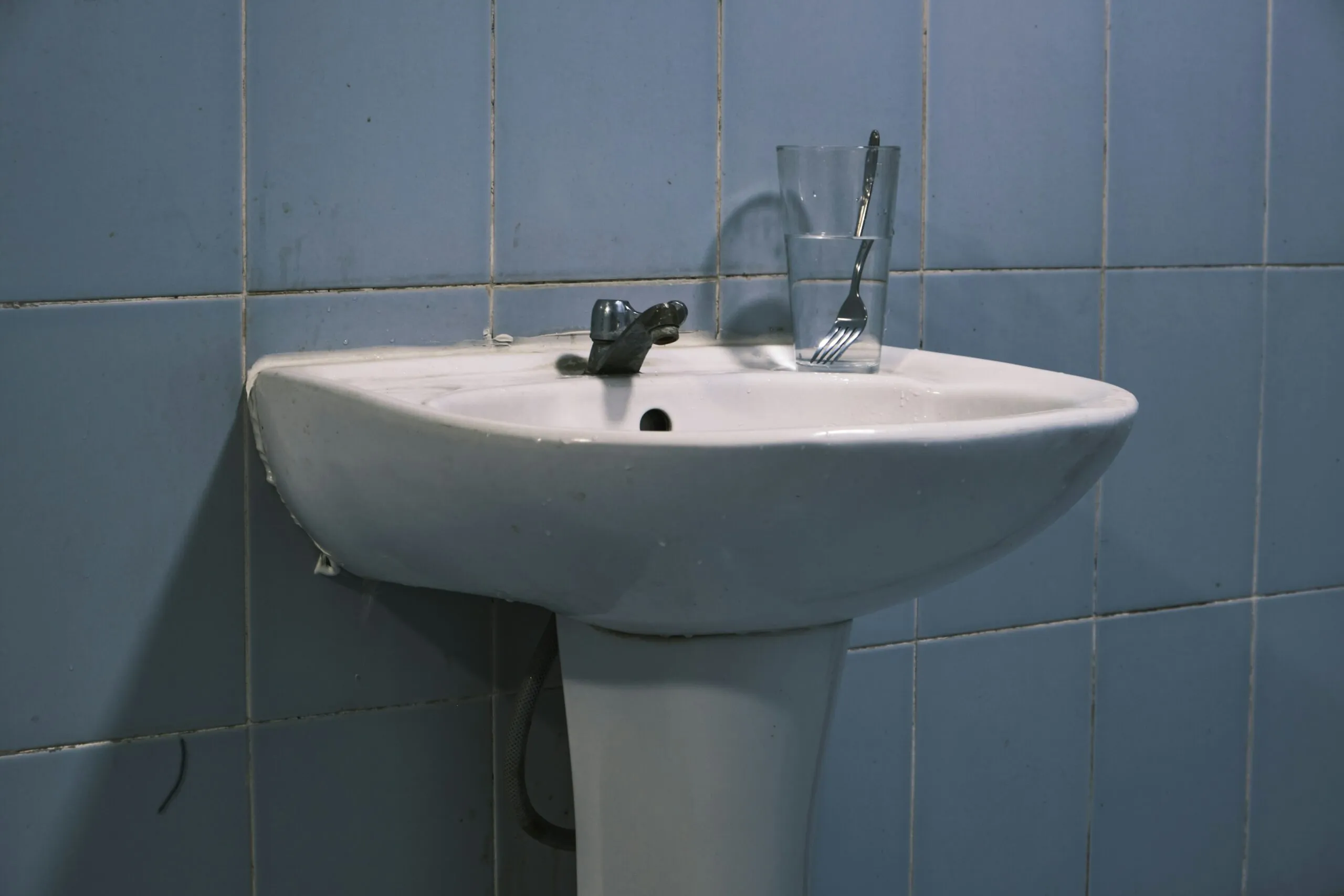 a sink with a faucet and a glass on top