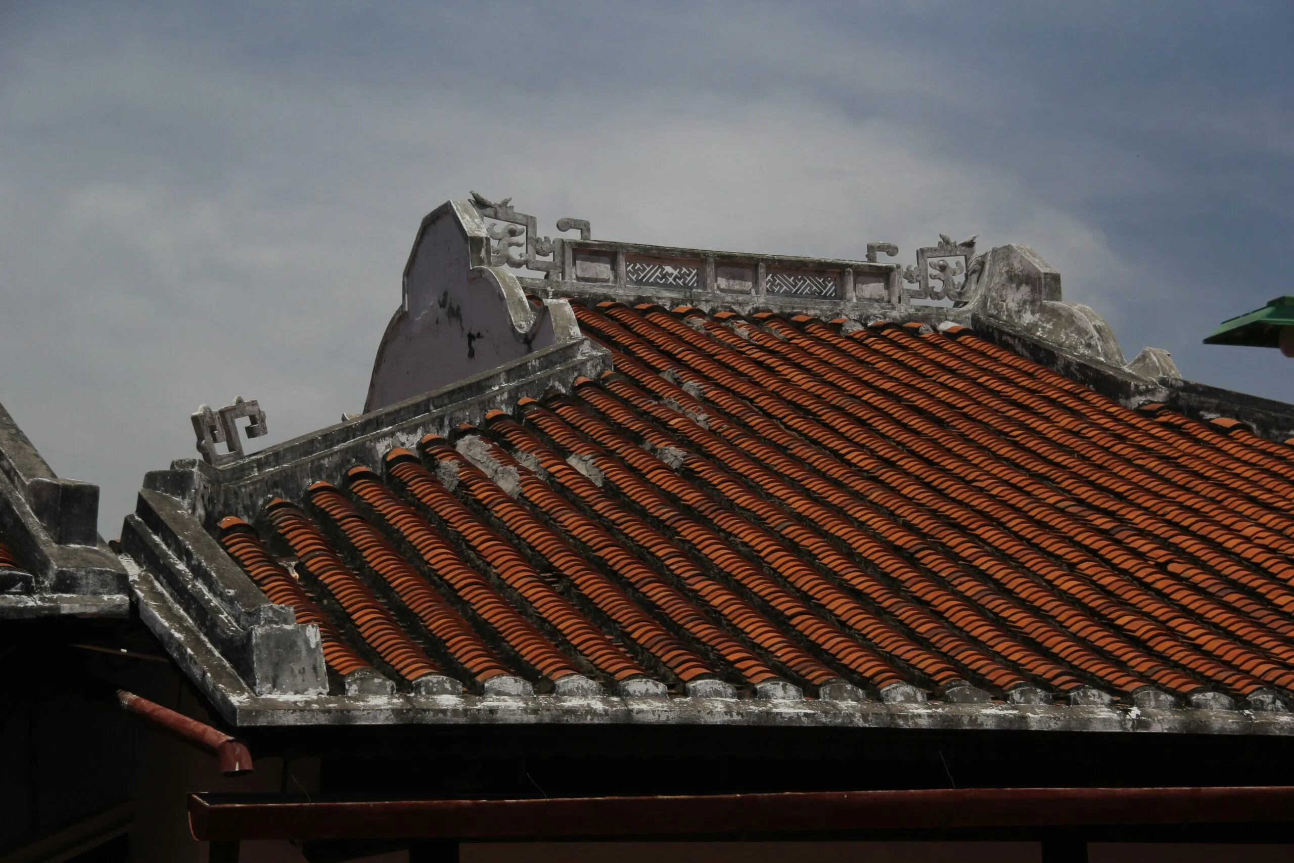 Traditional tiled roof with ornate detailing against sky