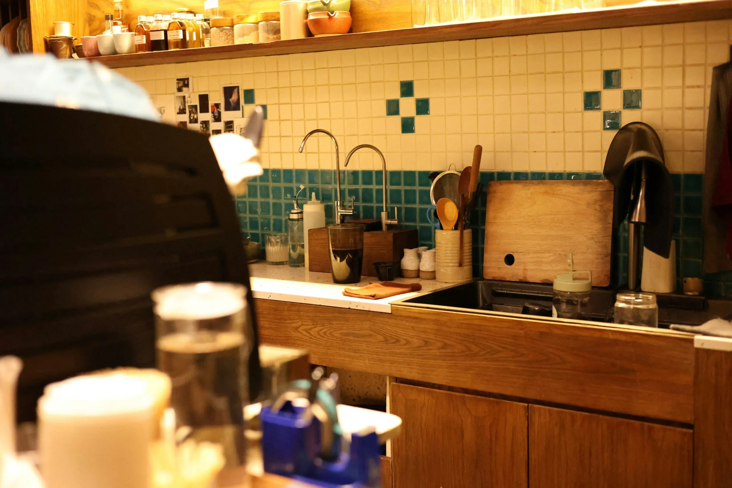 A kitchen's sink, tiles, and utensils.