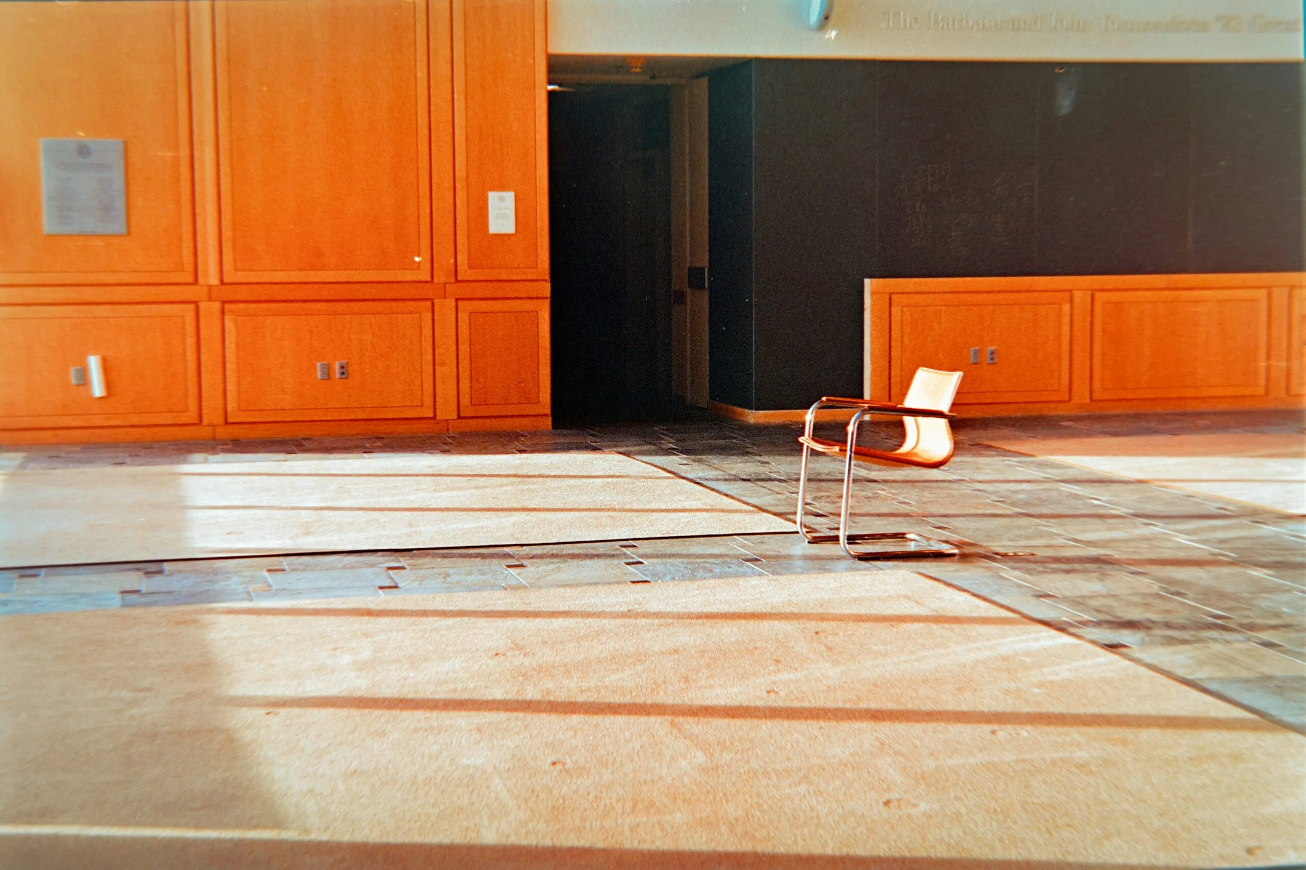 Empty room with wooden walls and a single chair.