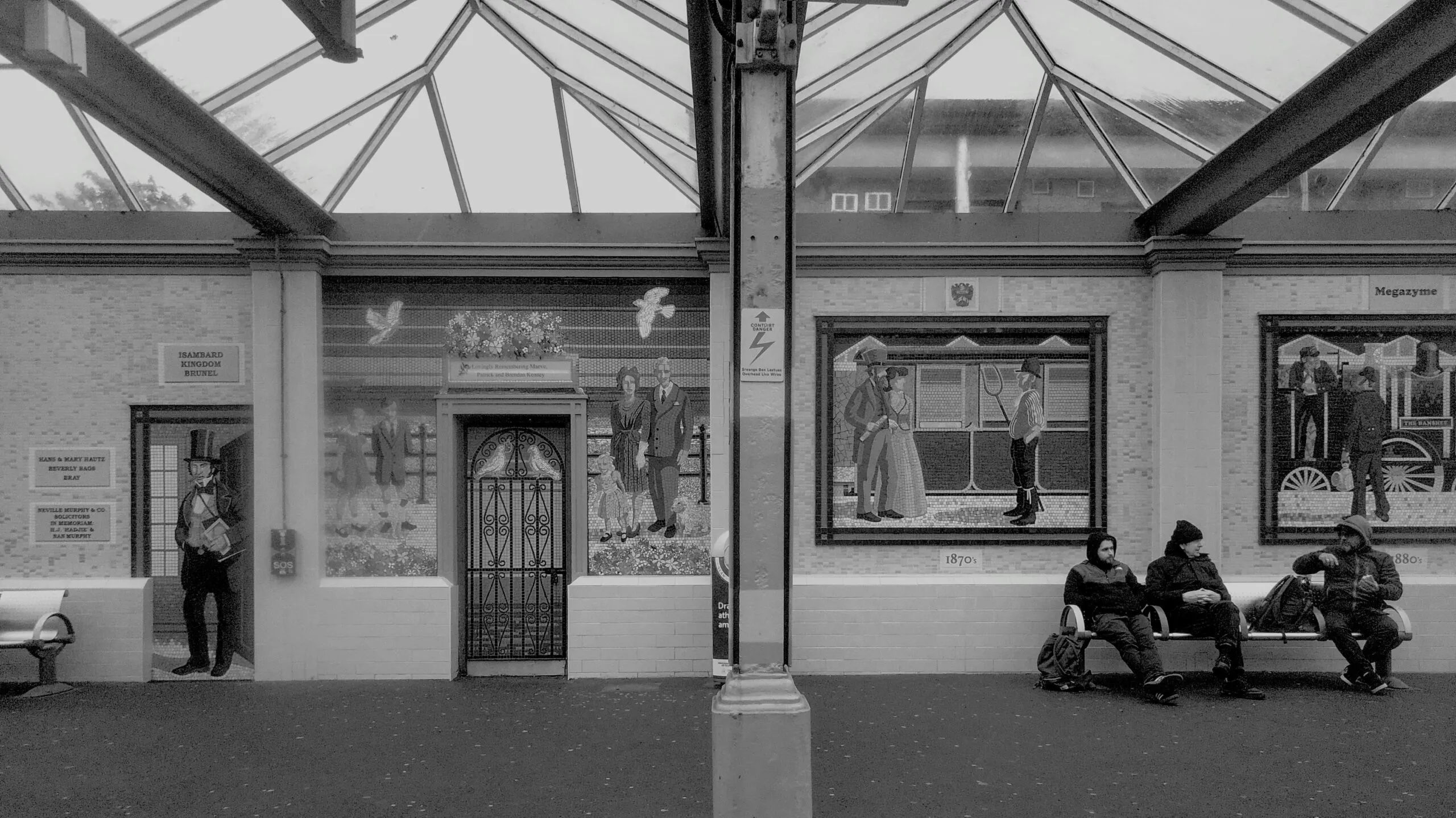 People waiting inside a building with murals