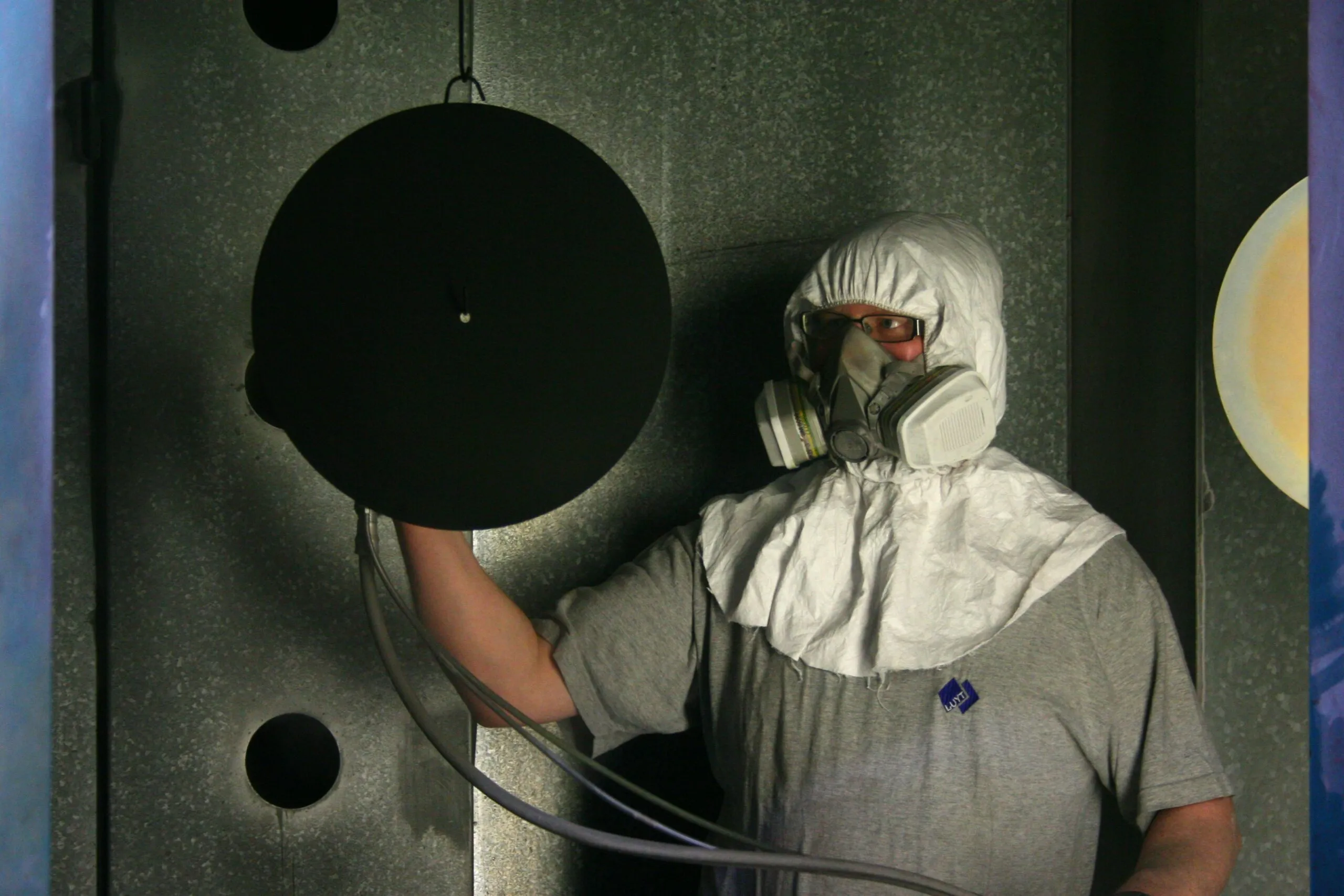 Person in hazmat suit holding a circular object