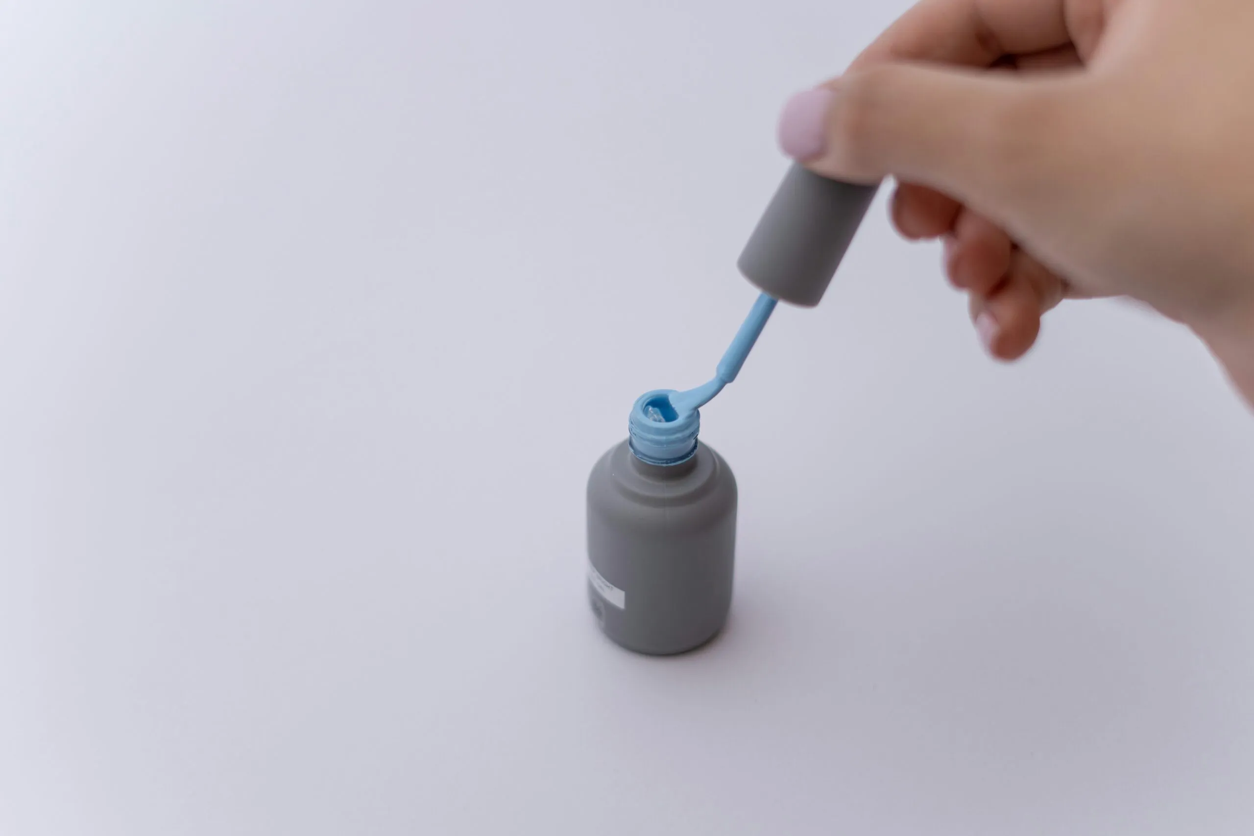 a hand holding a white tube