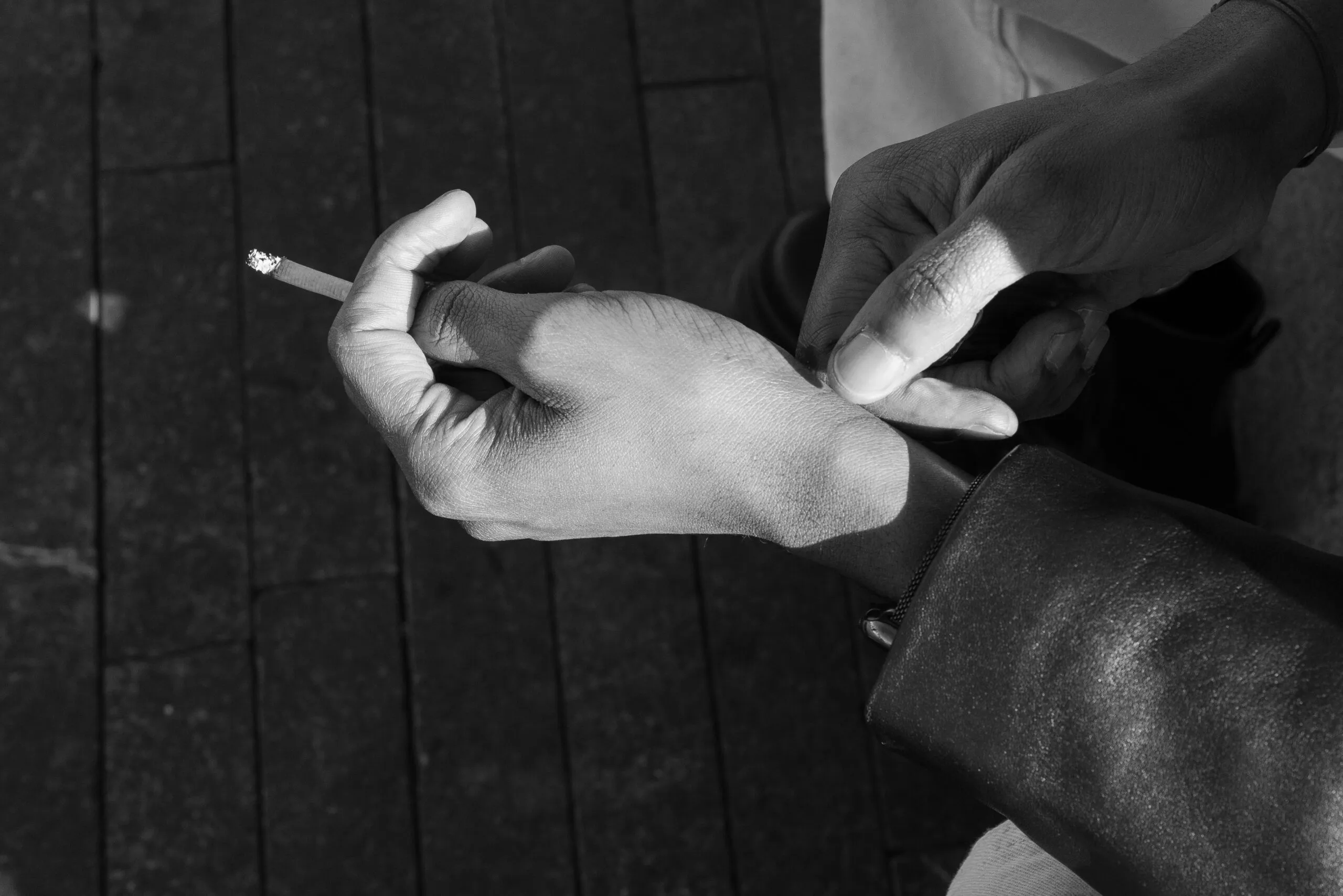 Someone is holding a lit cigarette.