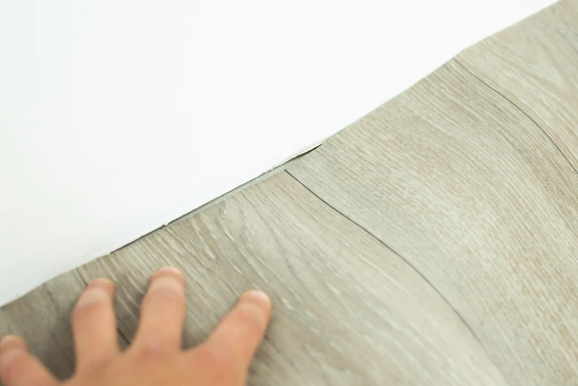 Laying down new linoleum on floor Making surface even near the wall