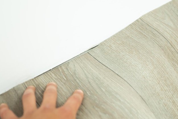 Laying down new linoleum on floor Making surface even near the wall