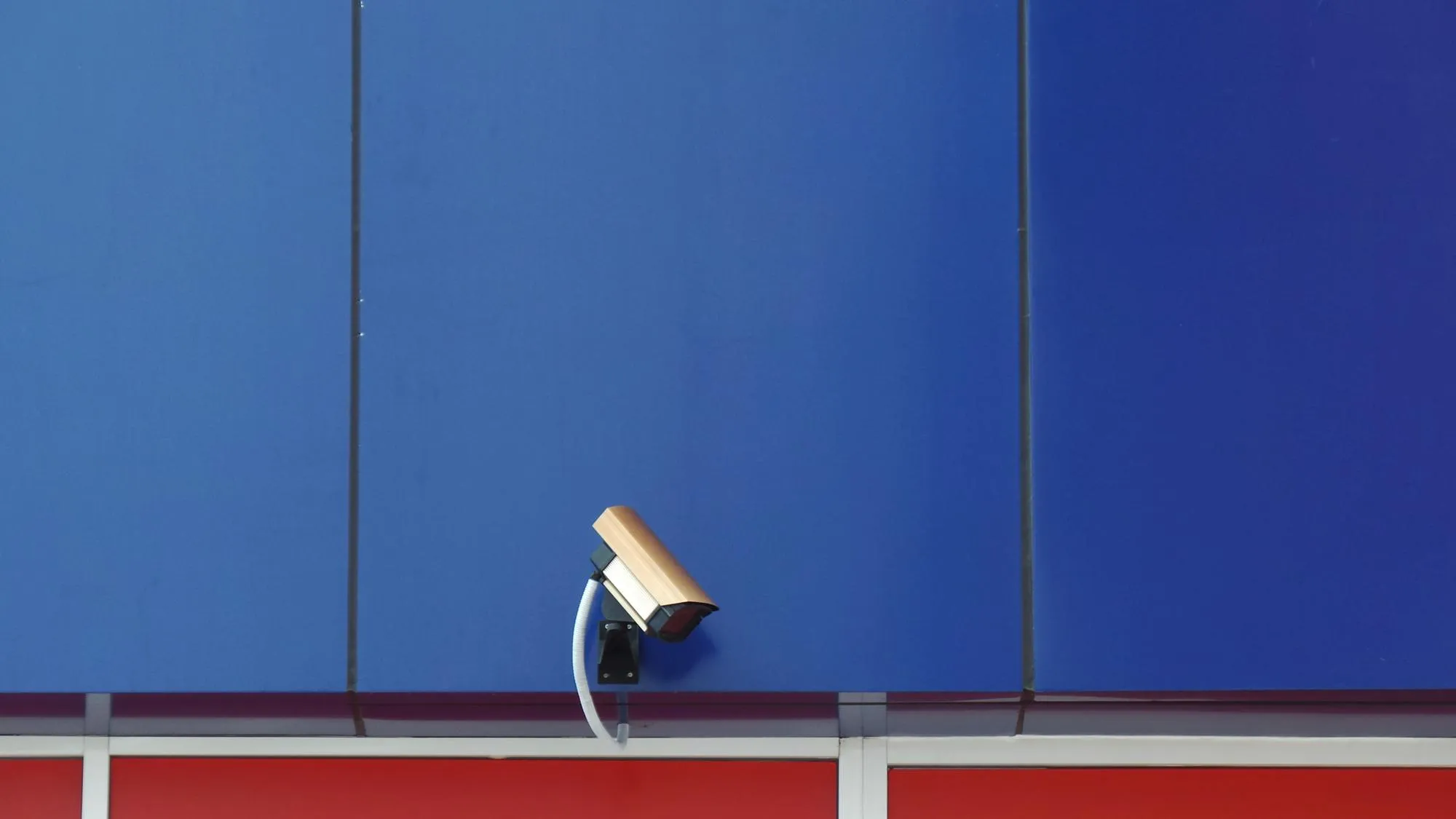 Low angle view of security camera on blue wall