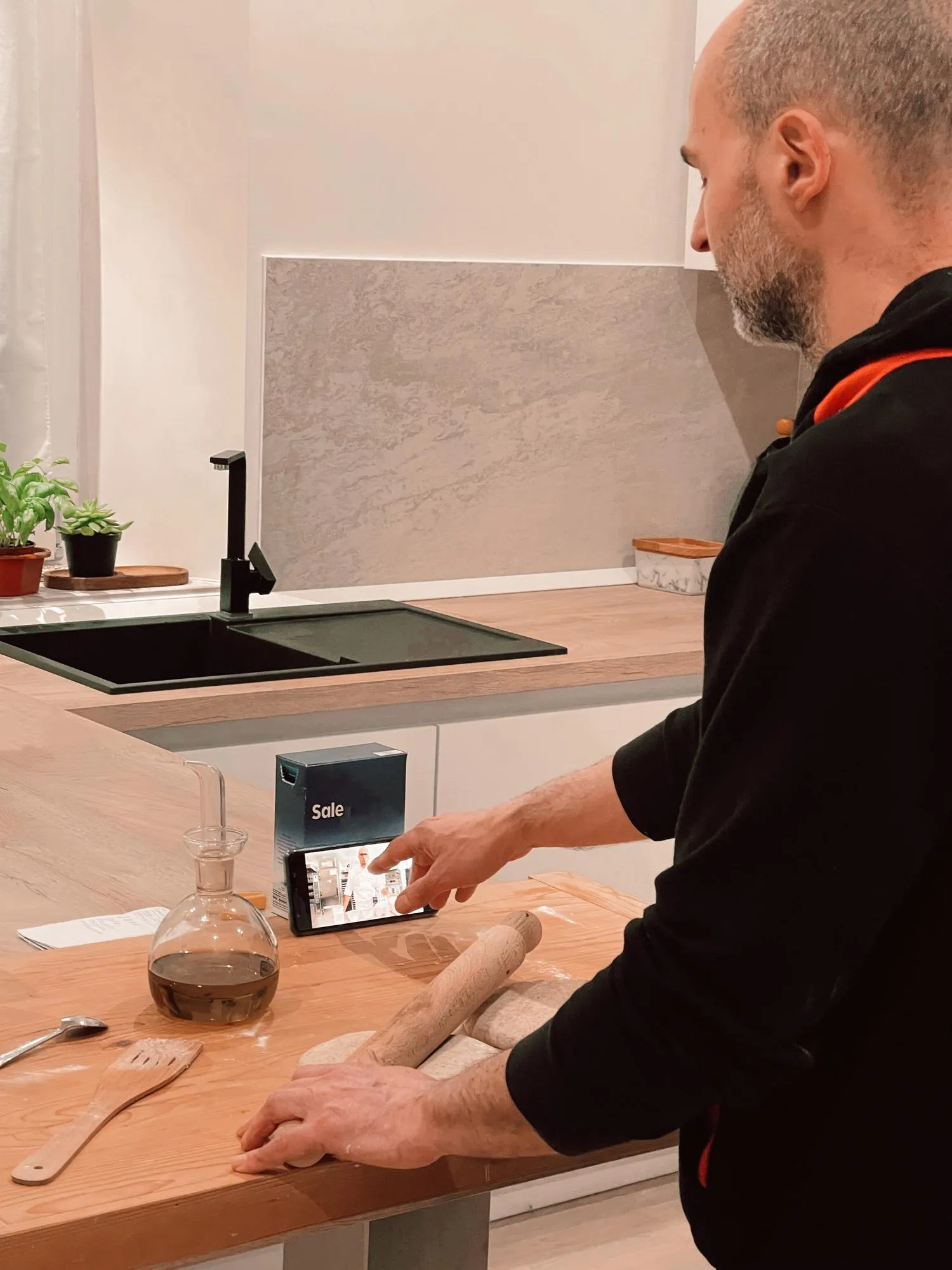 Man cooking at home using video tutorial