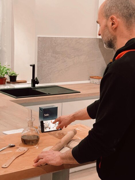 Man cooking at home using video tutorial