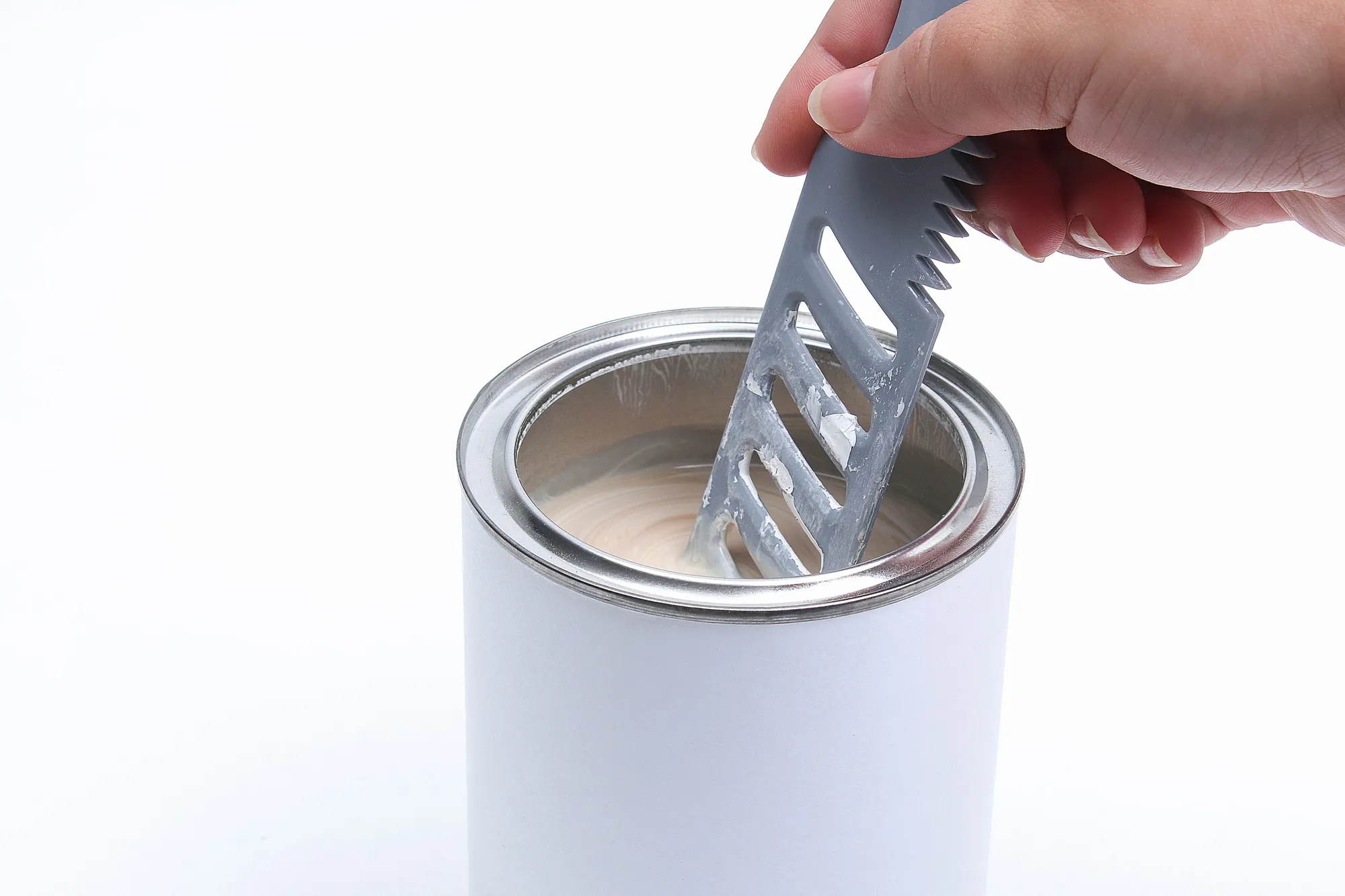 man stirring white paint in a can on a white background. Renovation concept.
