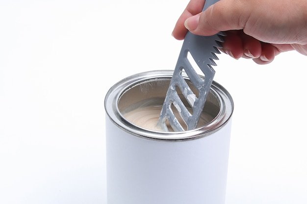 man stirring white paint in a can on a white background. Renovation concept.