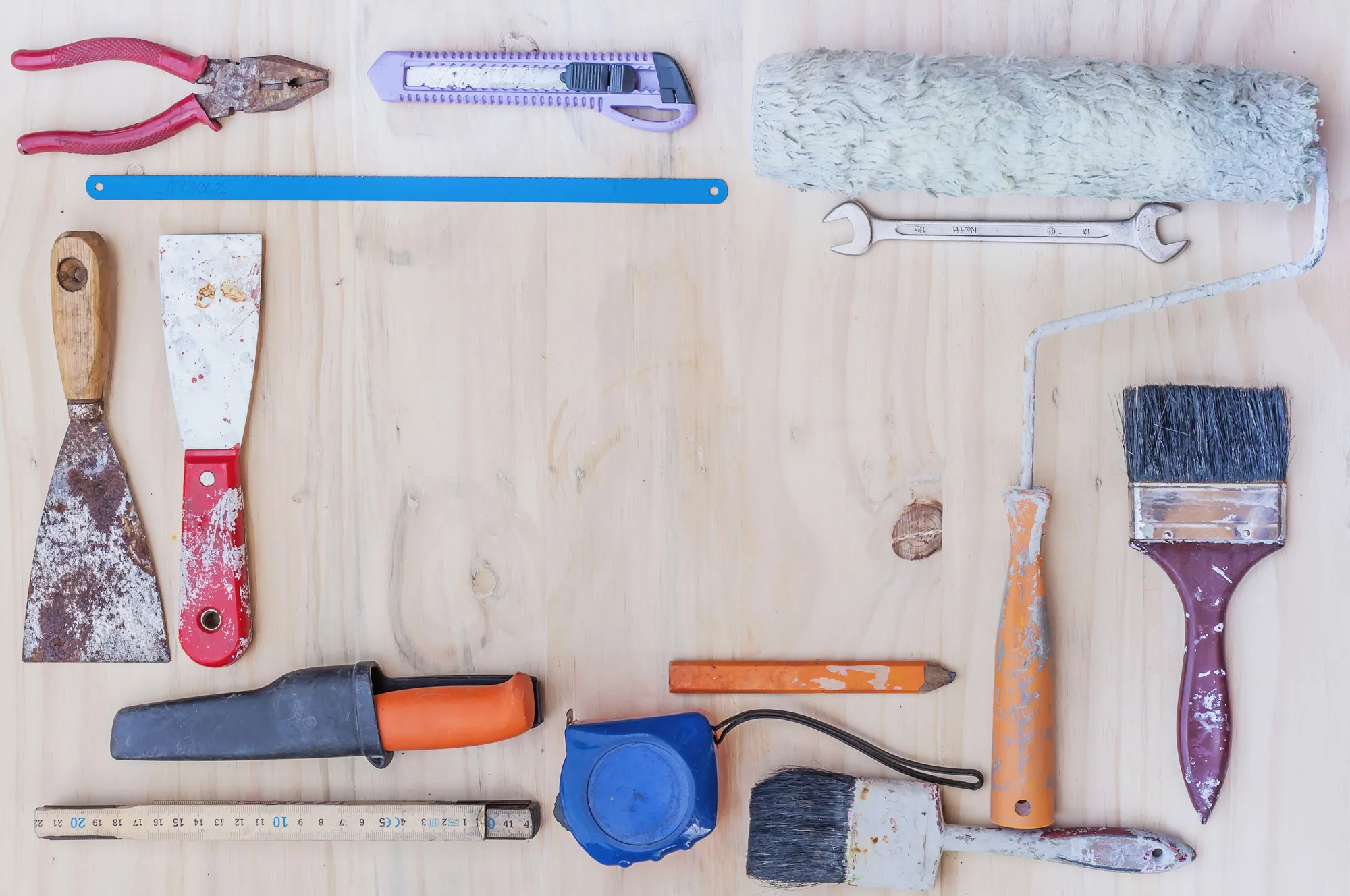Old construction hand tool over white wooden background