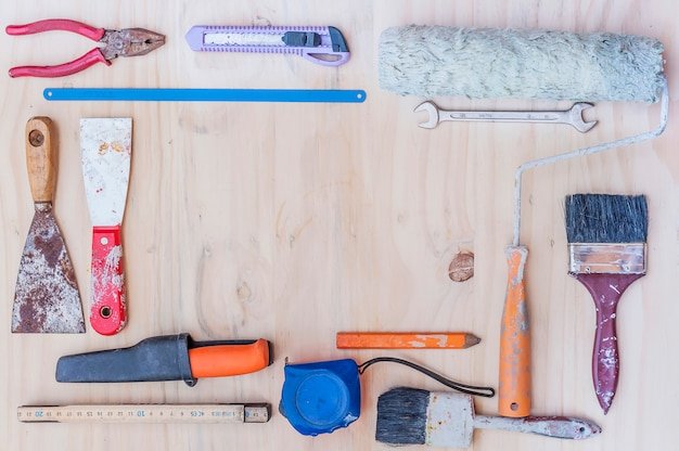 Old construction hand tool over white wooden background