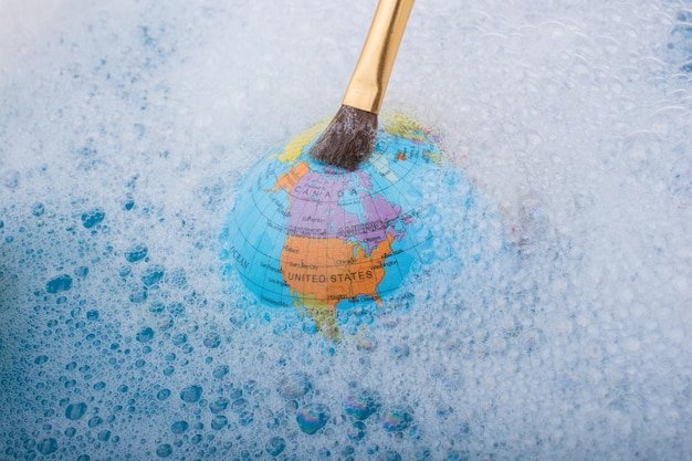 Paint brush placed on the top of globe