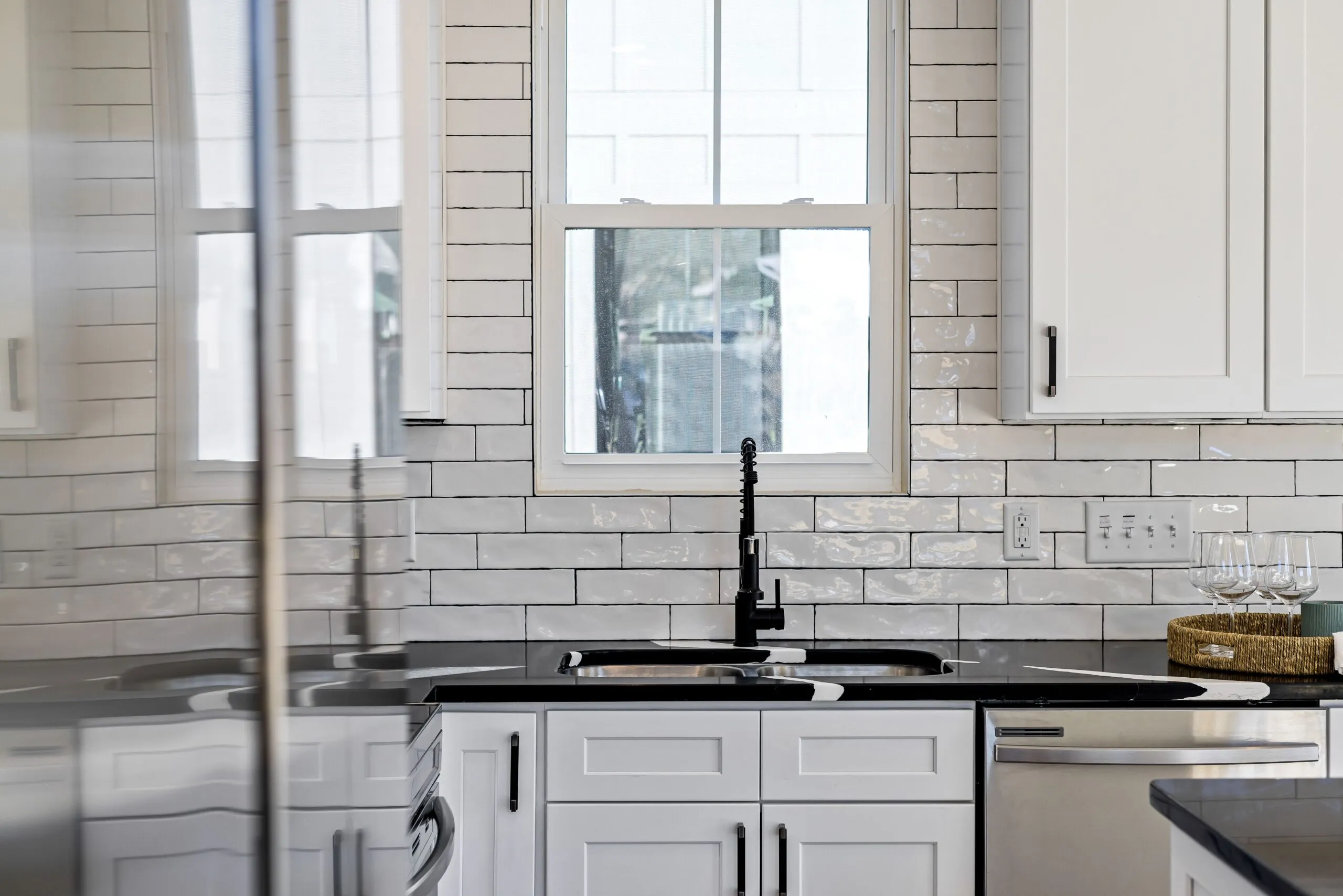 Sleek kitchen with black countertops, white cabinets, and modern design elements.