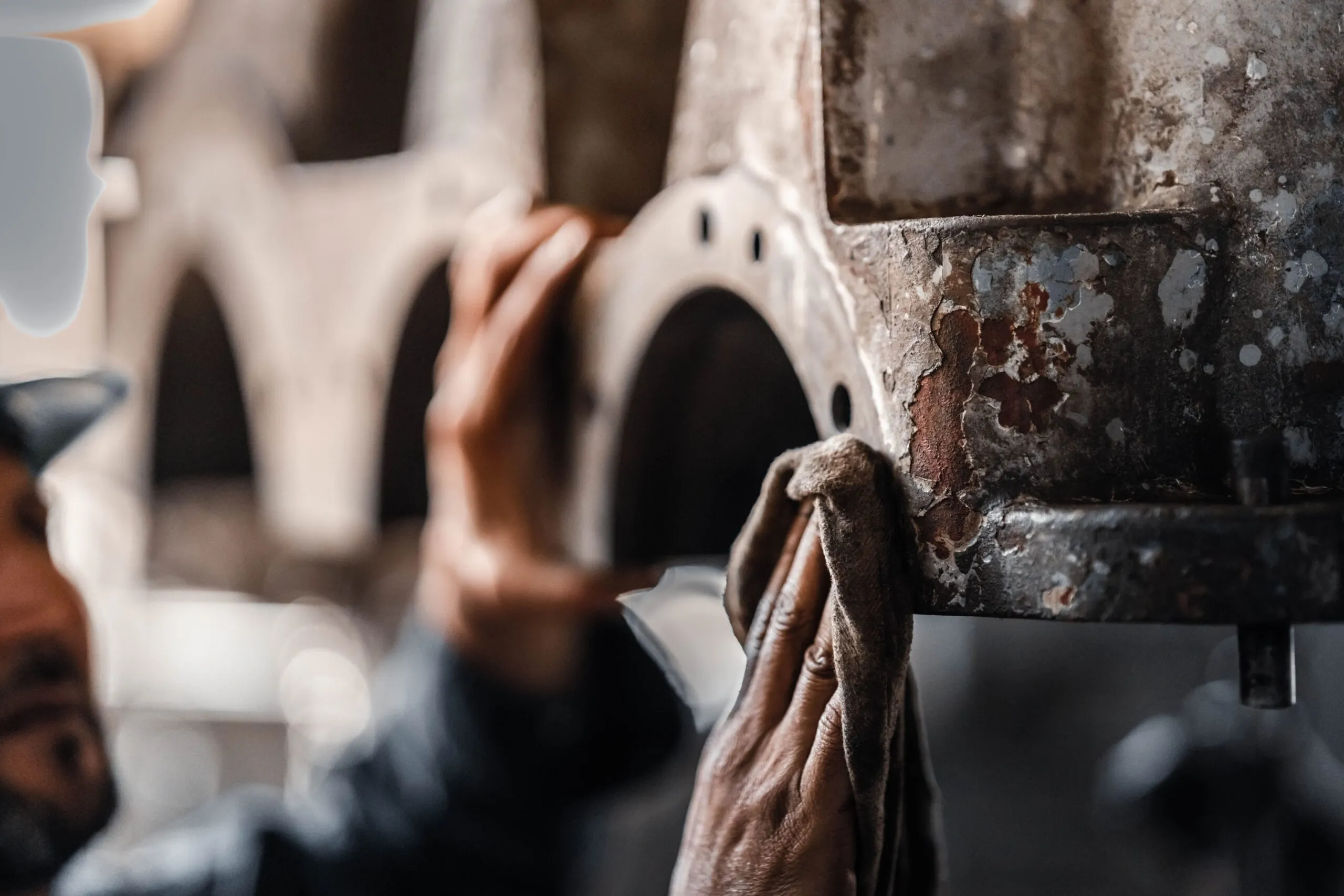 Close-up of a worker cleaning and maintaining industrial machinery in a workshop in Libya.