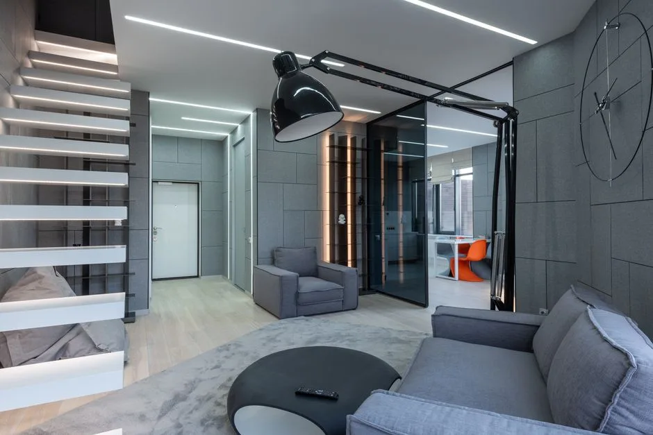 A sleek contemporary living room featuring minimalist furniture and modern lighting design.
