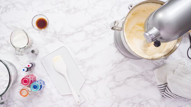 Step by step. Mixing ingredients in standing kitchen mixer to make buttercream frosting.