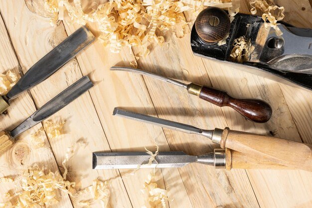 Top view of a traditional carpenter tools and wood shavings lying on wooden planks