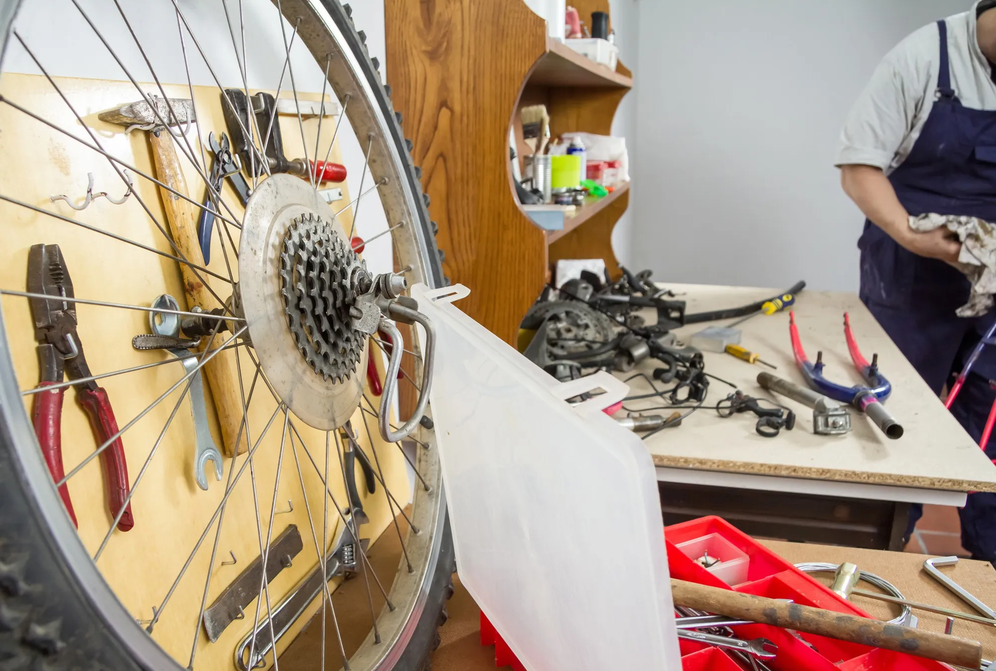 Wheel and bicycle parts over workshop table in the restoration process of a damaged bike