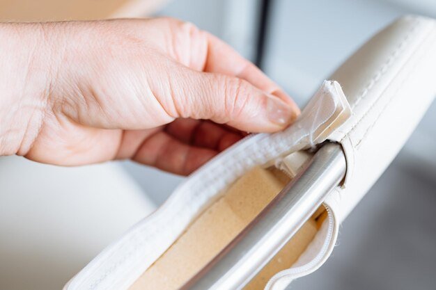 Womans hand demonstrates a torn zipper damaged