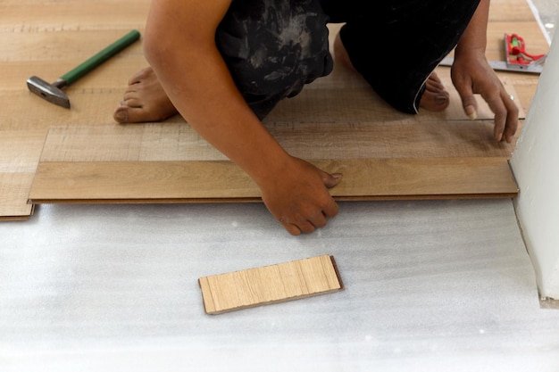 worker joining vinyl floor covering at home renovation
