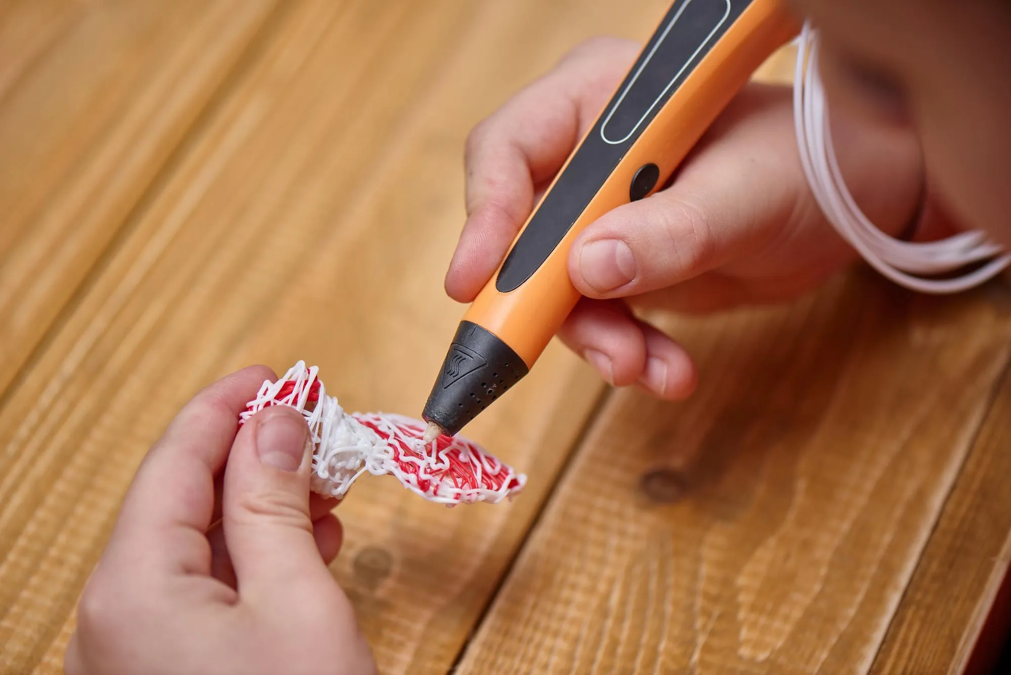 Boy makes volume plastic figures with 3D pen. STEM educational toy for kids at home and school. Play and study, close up