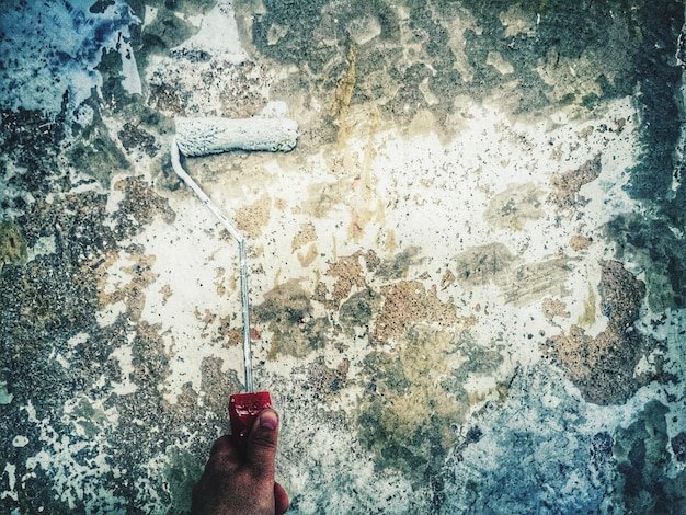 Close-up of painting wall with paint roller
