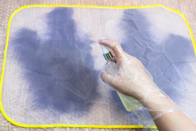 Craftsman wetting first layer of fibers by spray