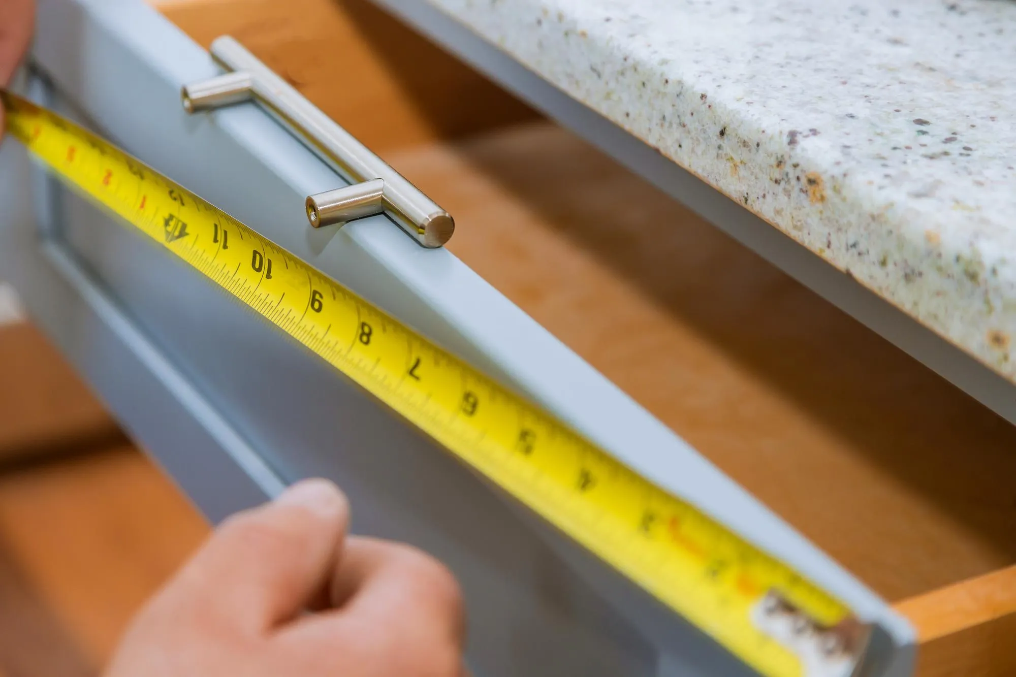 Cropped hand of carpenter measuring drawer