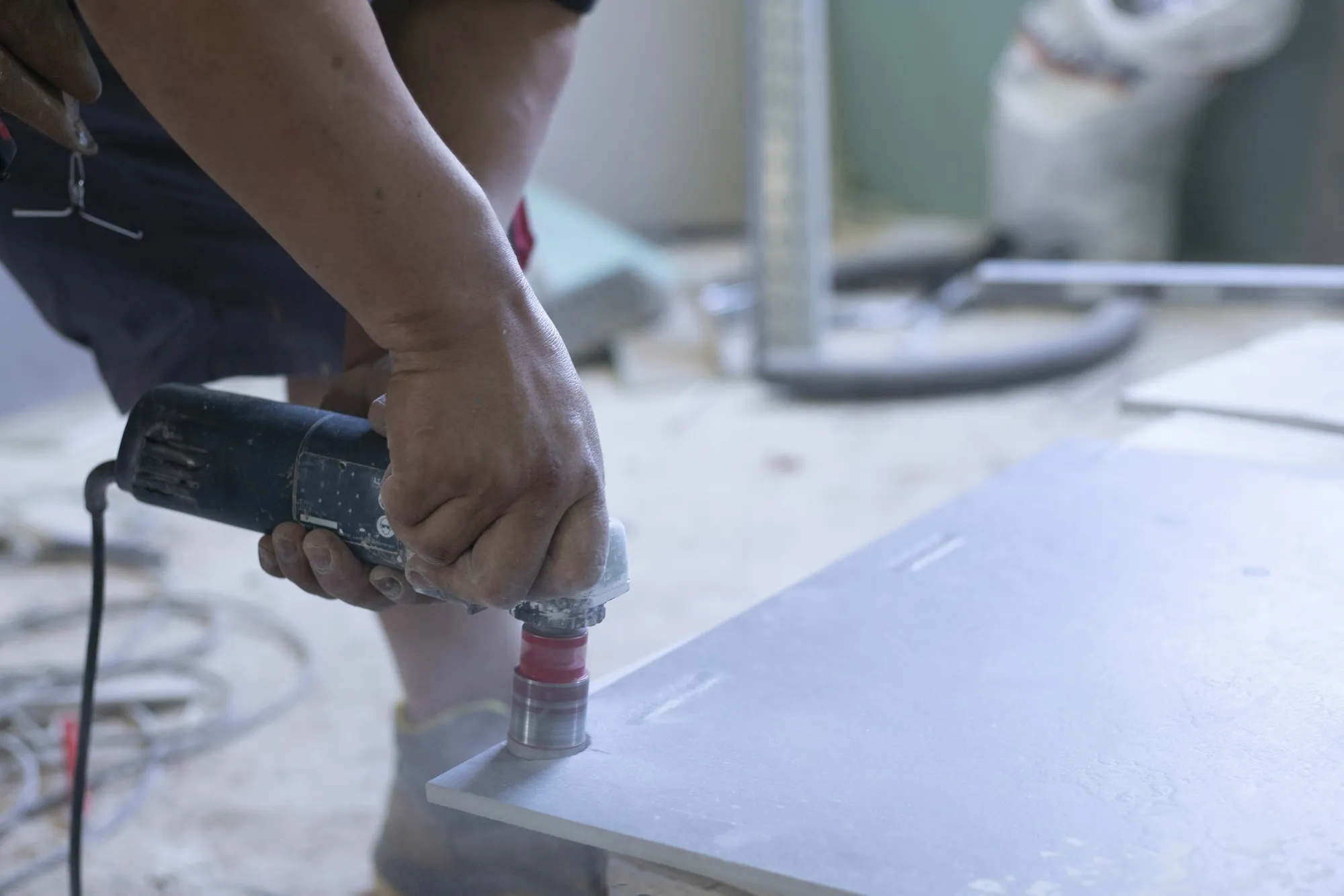 Hands of latin worker drilling holes in tile