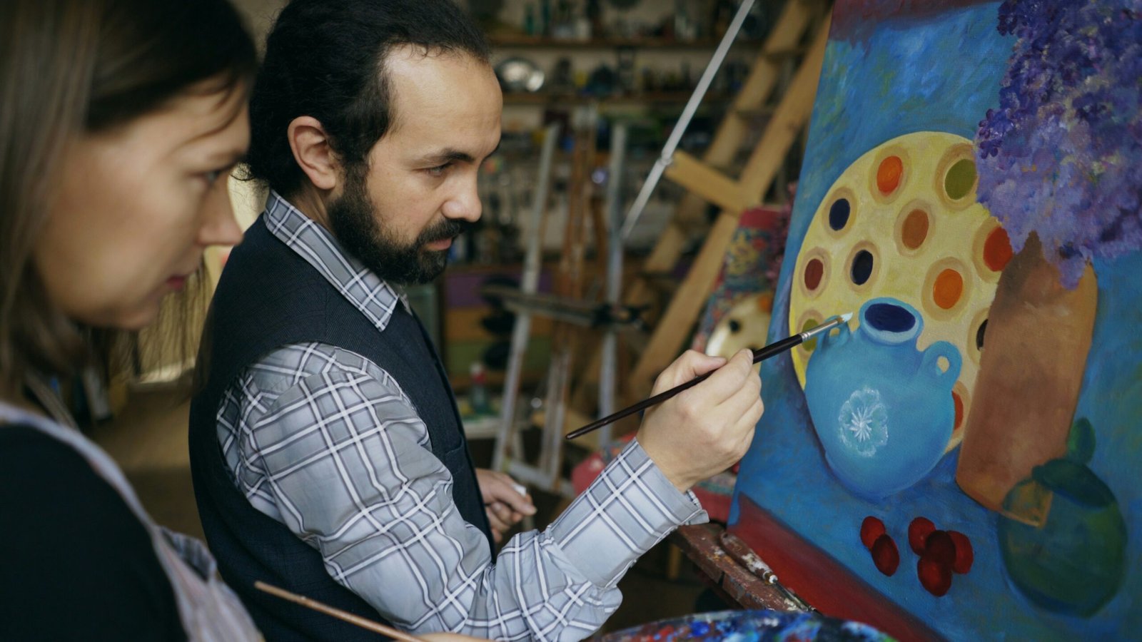 Two artists painting a still life in a studio.