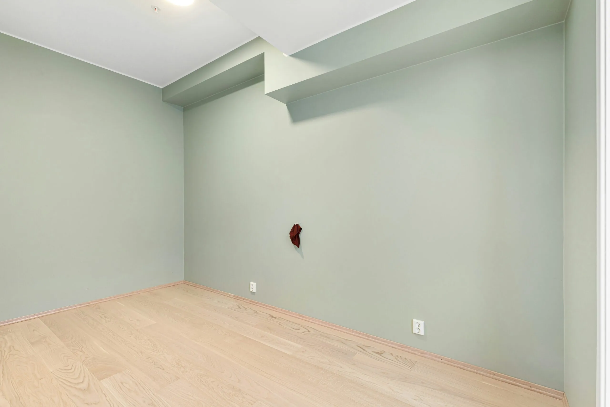 A empty room with a wooden floor and a ceiling fan