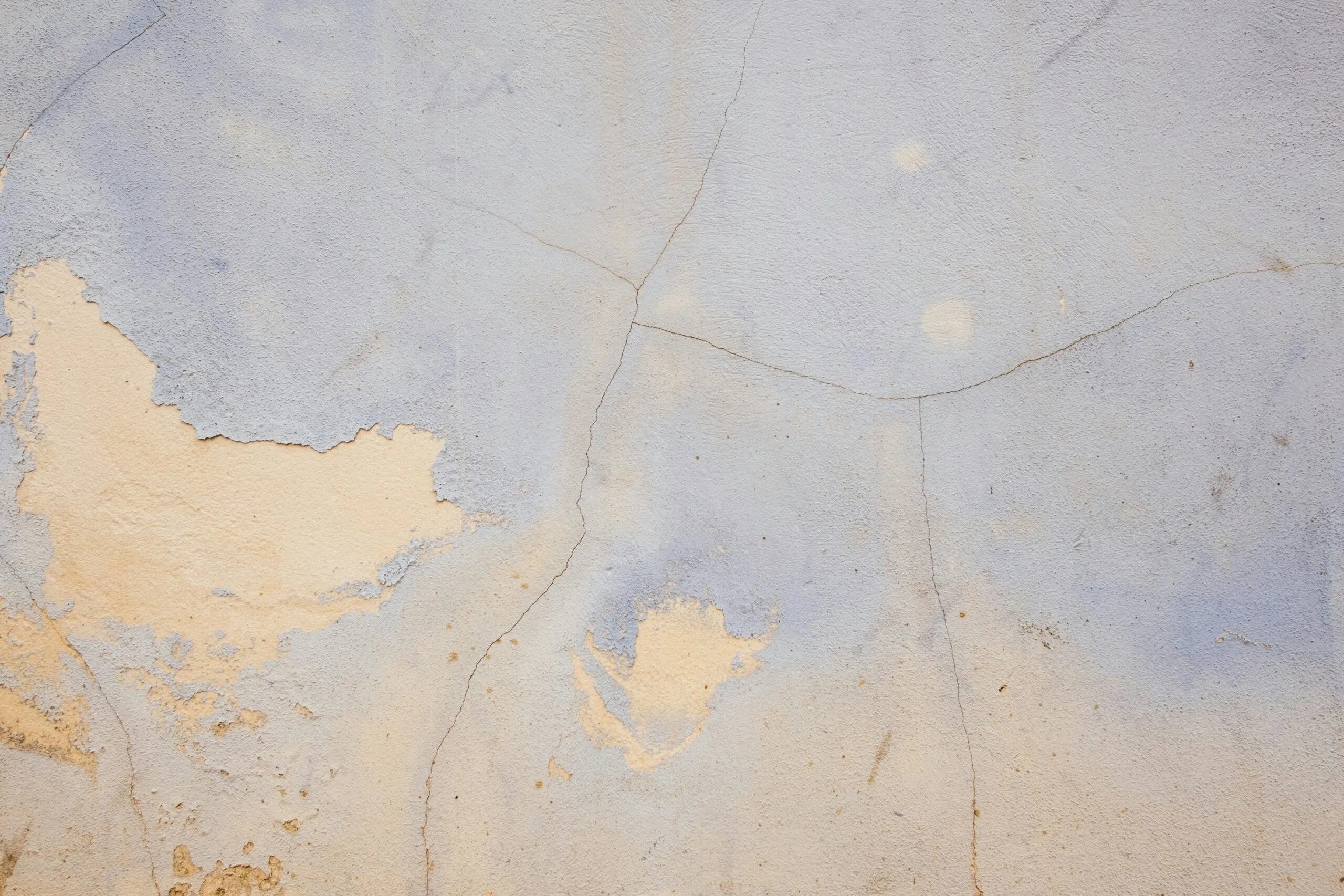 a white and blue wall with peeling paint