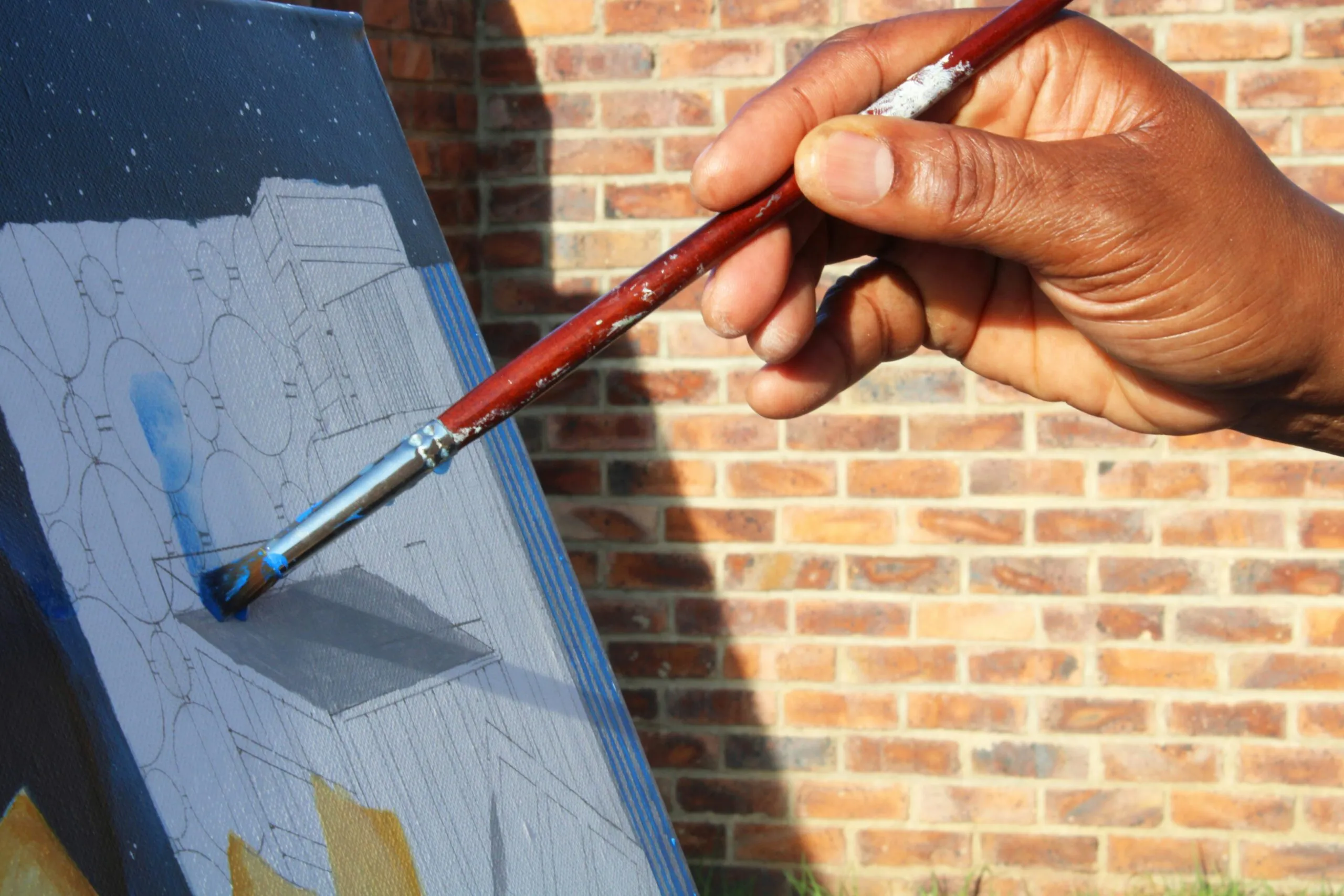 a person is holding a paintbrush and painting a picture