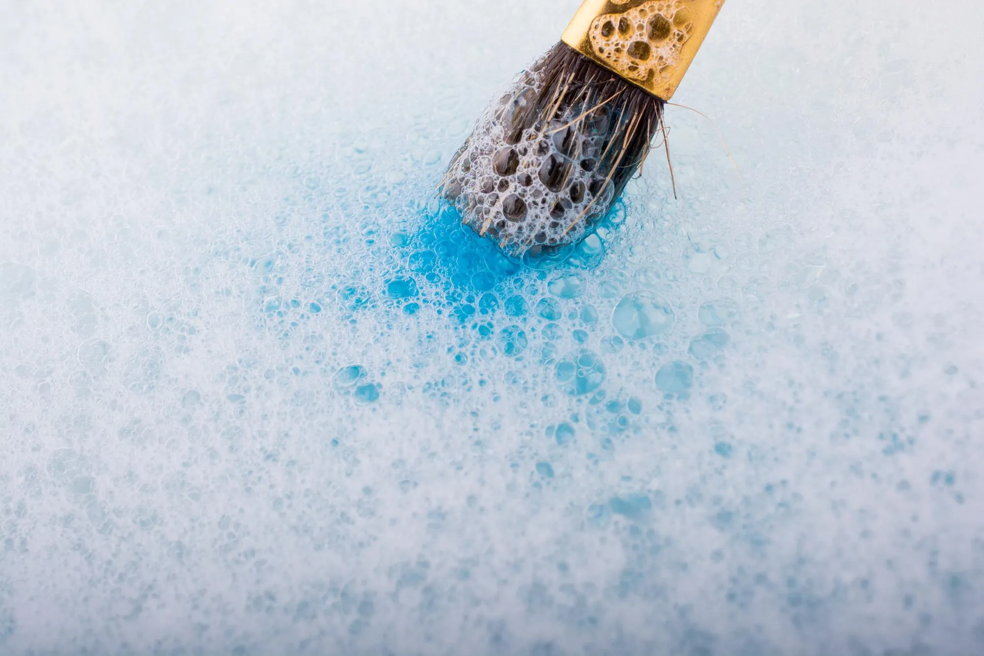 Paint dissolving as painting brush touches water